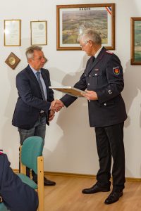 Kai Hauschildt ernennt Ehrenbürgermeister Holger Klose zum Ehrenlöschmeister.