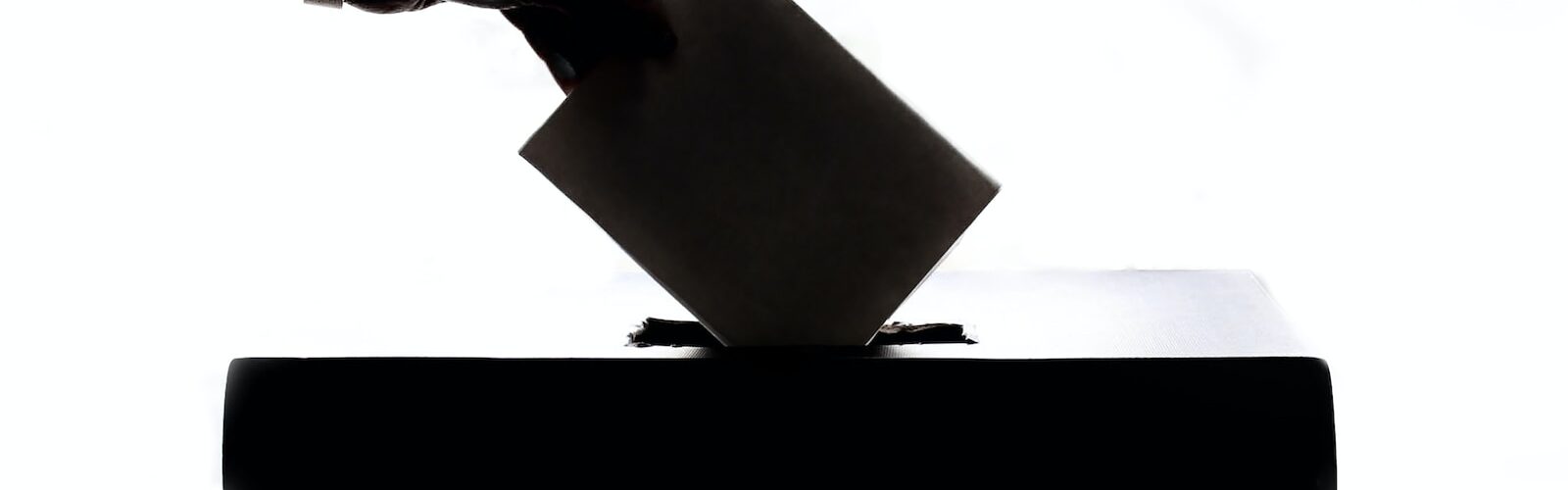 a person is casting a vote into a box