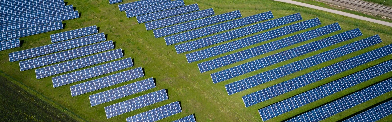 aerial photography of grass field with blue solar panels