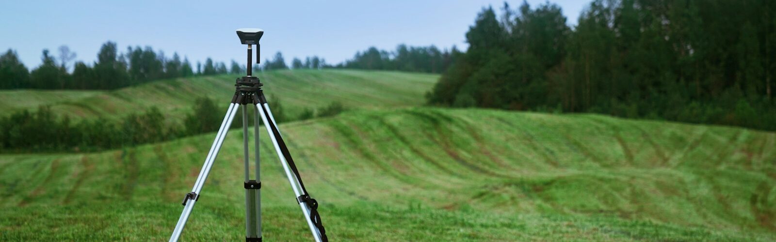 black and white tripod on green grass field during daytime