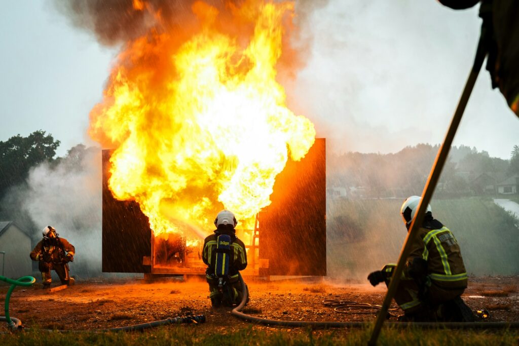 a group of fire fighters standing around a fire